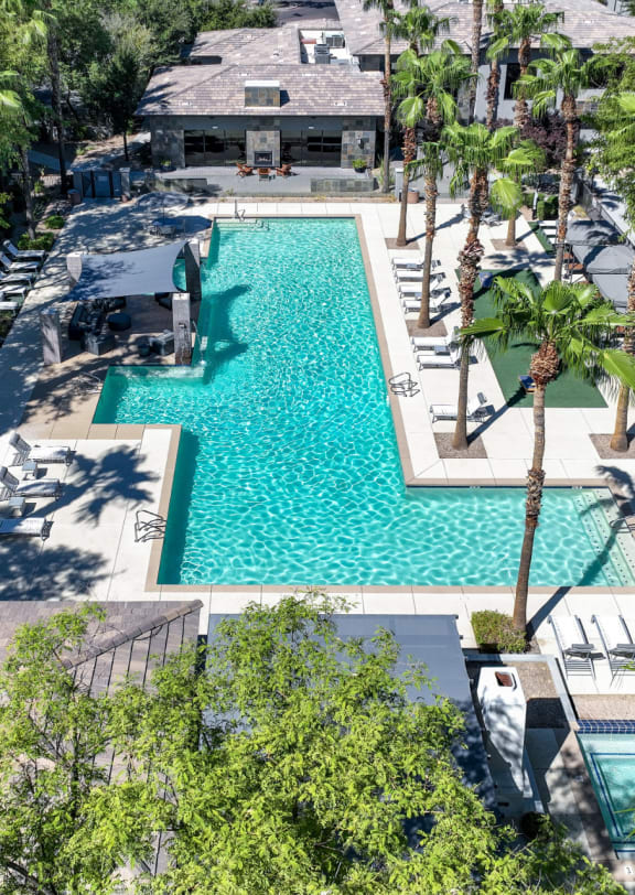 exterior pool view at Avora with palm trees, lounge chairs, and cabanas