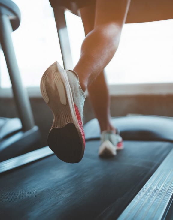 Person Running on Treadmill at Gym