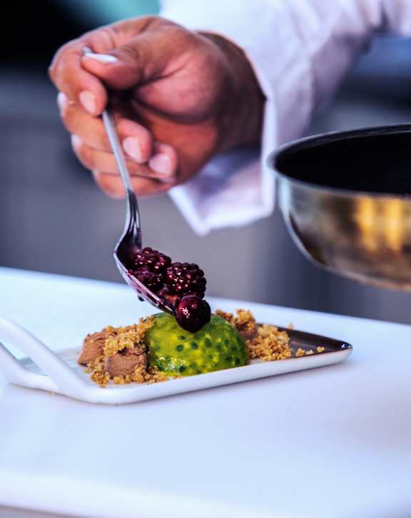 A person is holding a fork with a piece of food on it.