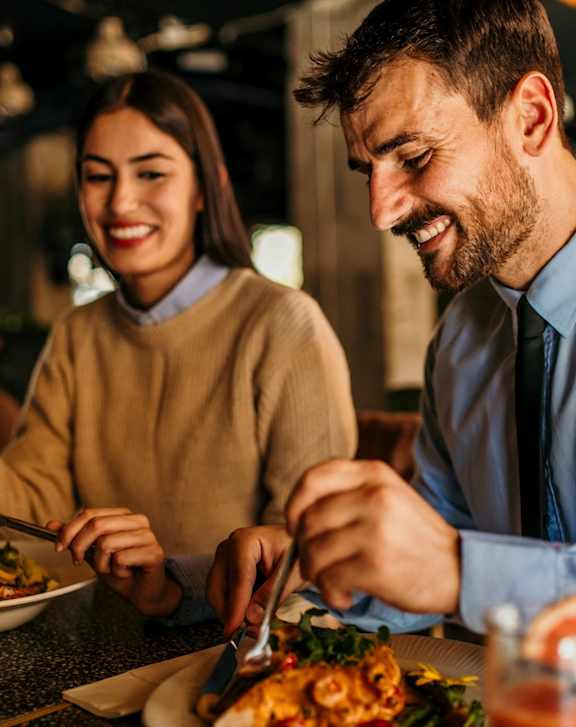 Man and Woman Enjoying Meal Together at Restaurant