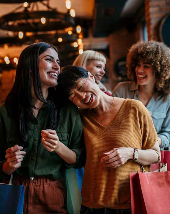 Women Laughing and Holding Shopping Bags