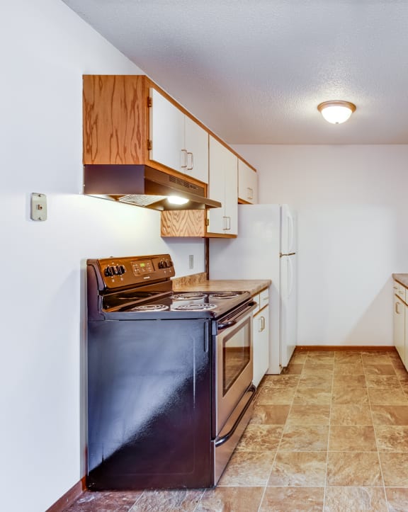 a kitchen with white cabinets and black appliances