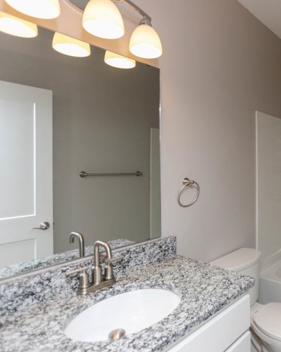 a bathroom with a sink toilet and mirror