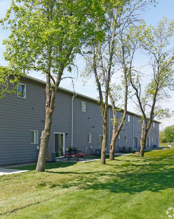 exterior view of the building with green grass and trees