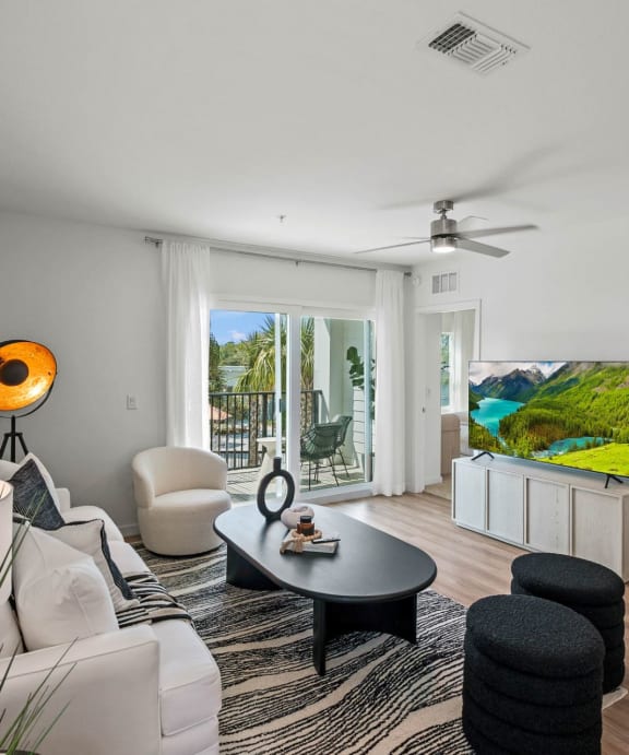 A modern living room with a flat screen TV and a ceiling fan. at Altis Twin Lakes Apartments, Kissimmee, FL 34744