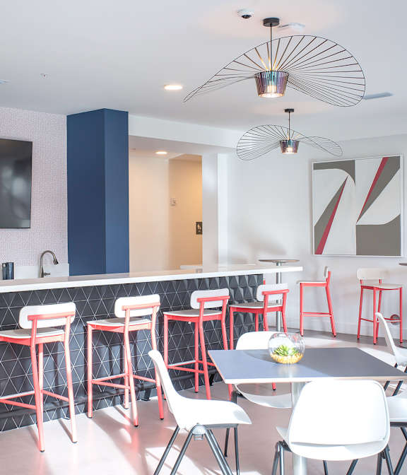 A modern bar area with a television and stools.