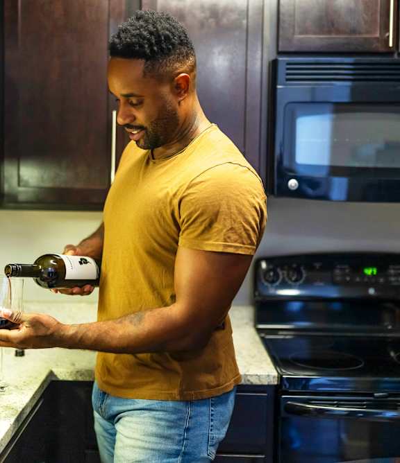 A man and a woman are preparing food together in a kitchen.