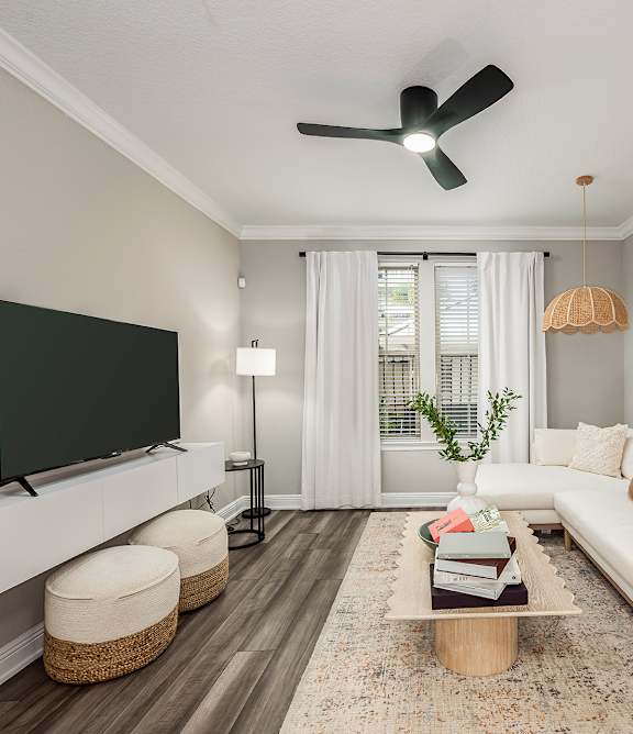 a living room with a couch and a desk with a laptop