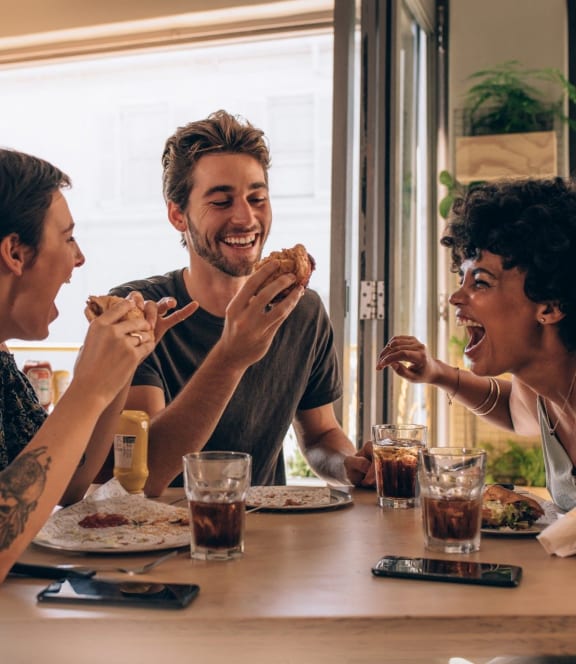 Friends Smiling while Having Lunch Together