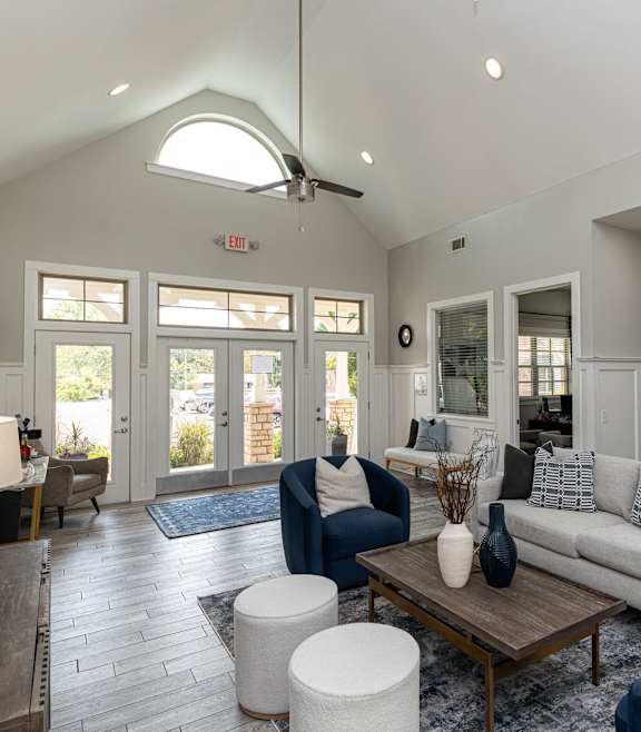 A living room with a white couch and blue chairs.