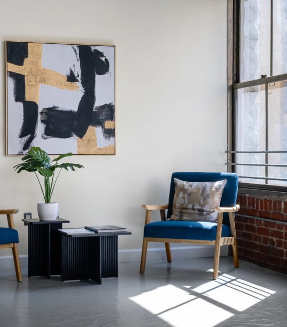 two chairs and a table in a room with a brick wall