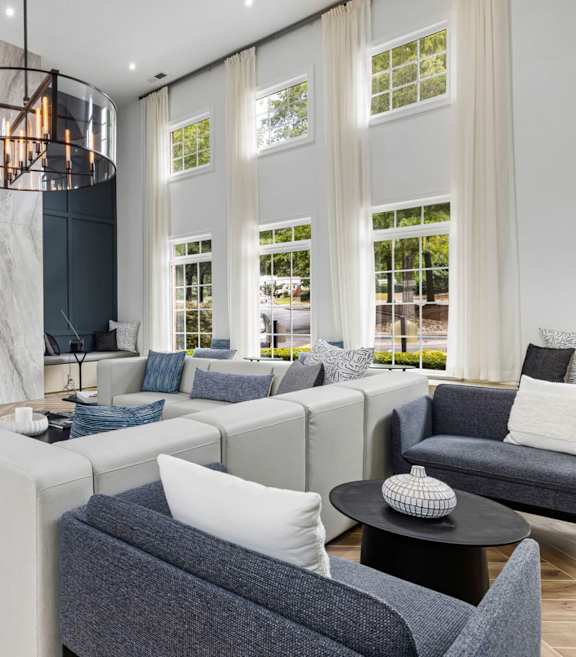 A modern living room with a fireplace and a large grey sofa.