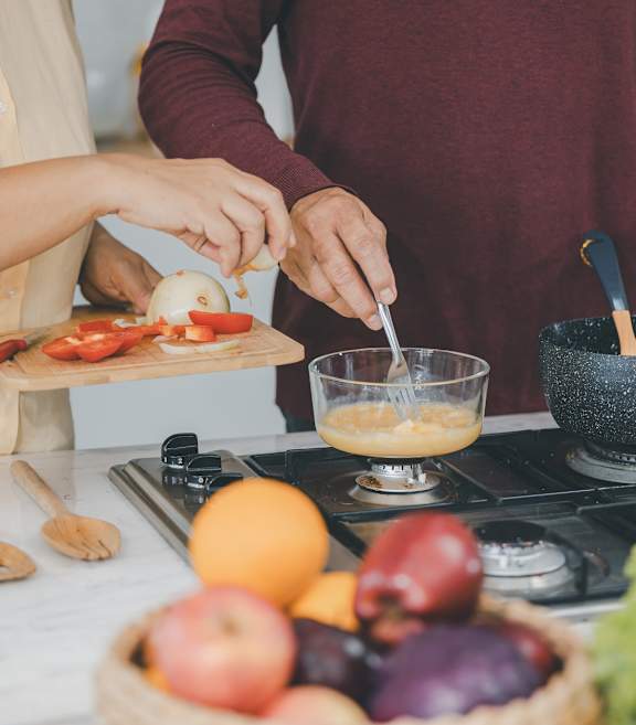 Two people preparing food in a kitchen.