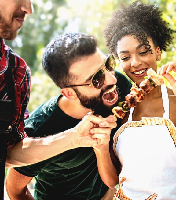Group of Friends Smiling and Eating at BBQ