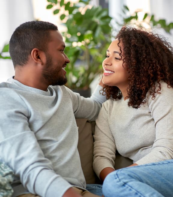 a man and woman sitting on a couch laughing