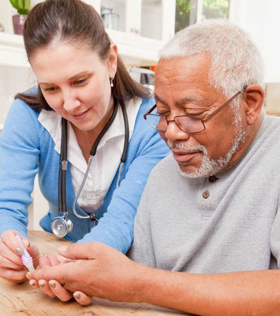 an older man and a young woman sitting at a table looking at a piece of paper