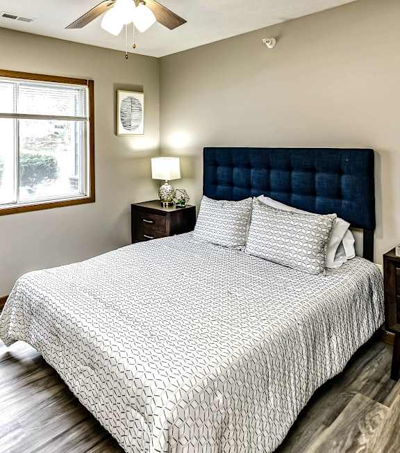A bedroom with a large bed and a window.
