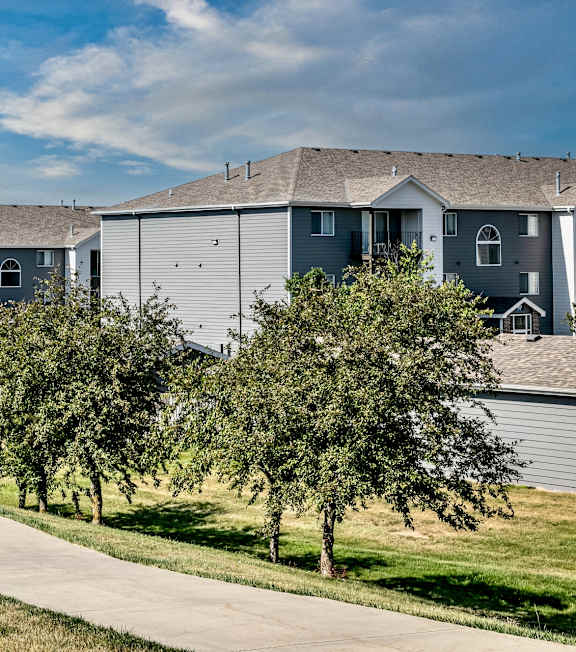 A row of houses with trees in front.