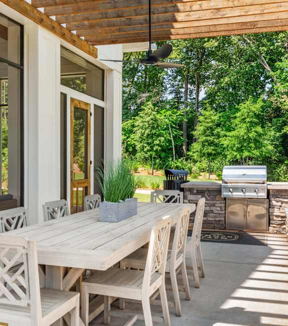 A wooden table and chairs are set up on a patio.
