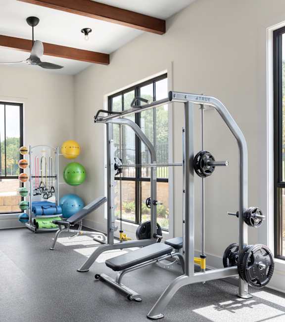 A spacious home gym with a variety of equipment including a squat rack, bench, and weights.