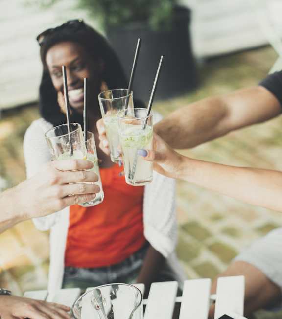 A group of people toasting with drinks in a social setting.