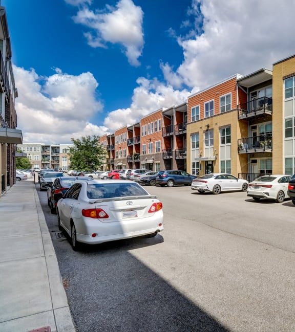 a city street with cars parked in front of apartment buildings