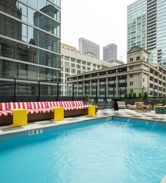 a swimming pool on the rooftop of a building with skyscrapers