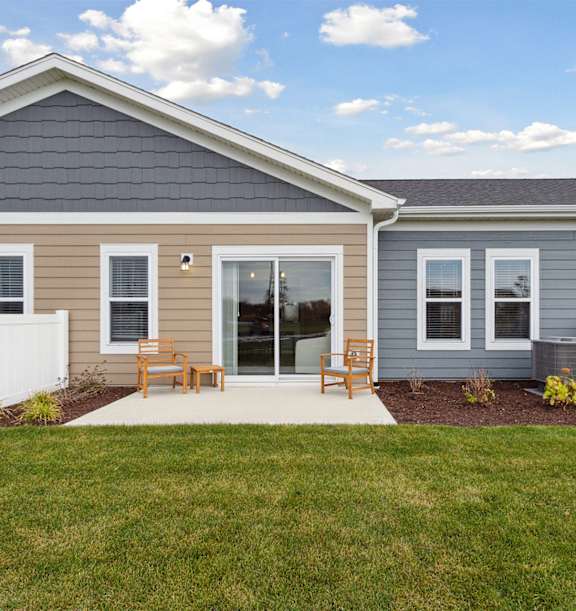 A house with a grey roof and a white fence.