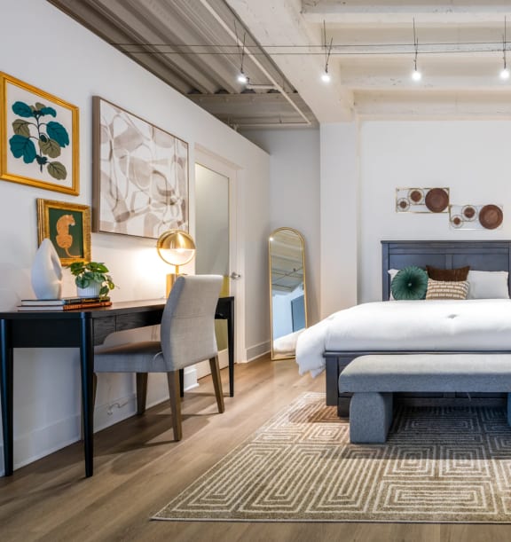 a bedroom with a bed and a desk with a chair