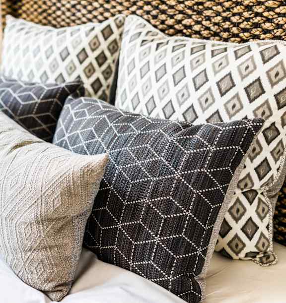 a pile of pillows on top of a bed