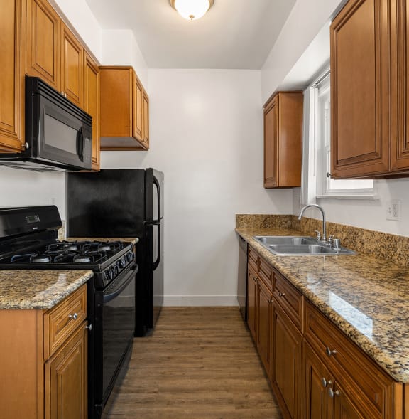 a kitchen with granite counter tops and black appliances