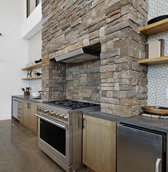 a kitchen with a large island and a dining room with a fireplace at Terraces at High Mountain, Huntsville