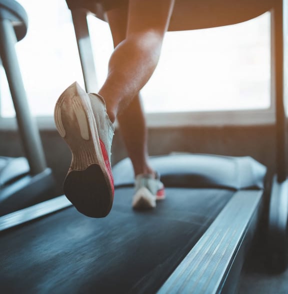 Man Running on Treadmill at Gym