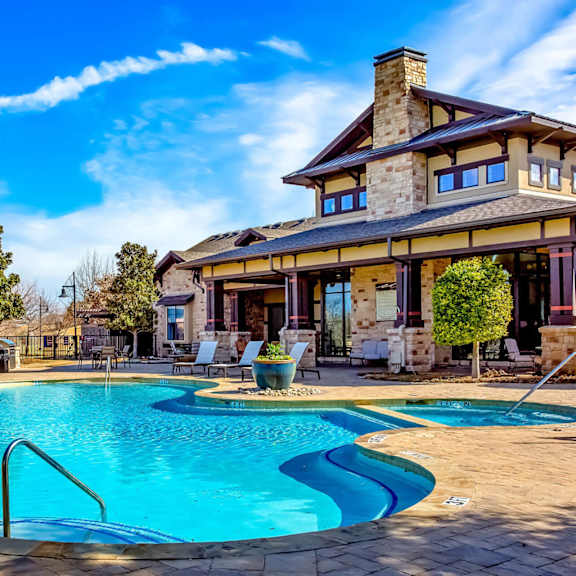A large house with a pool in front.