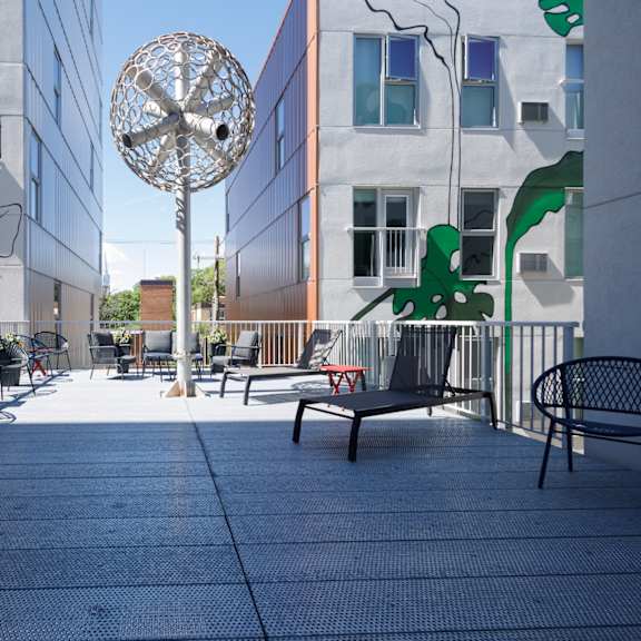 A patio with a table and chairs and a sculpture in the middle.