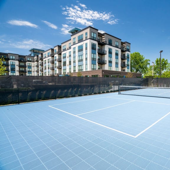 a tennis court with a building in the background