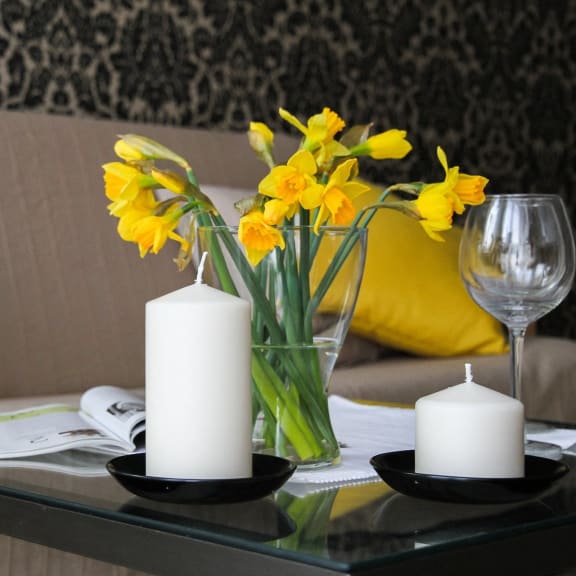 a table with candles and flowers on a couch