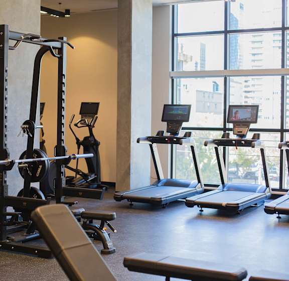 A gym with treadmills, weightlifting equipment and a rowing machine.