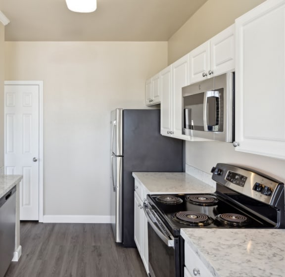 spacious kitchen with white cabinets and stainless steel appliances at Bridgeport Ranch apartments
