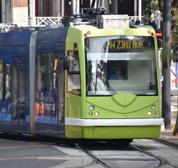 a green and blue tram is on the tracks at The Parker, OR 97209
