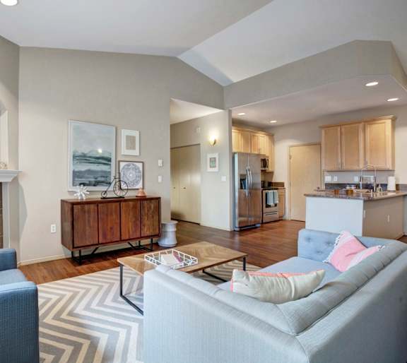 A living room with a grey couch and a fireplace.