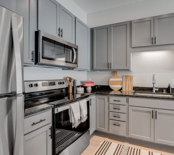 a kitchen with stainless steel appliances and gray cabinets
