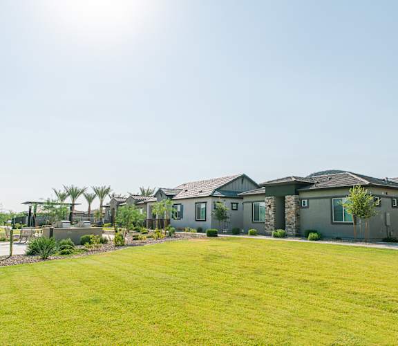 A row of houses with green lawns in front.
