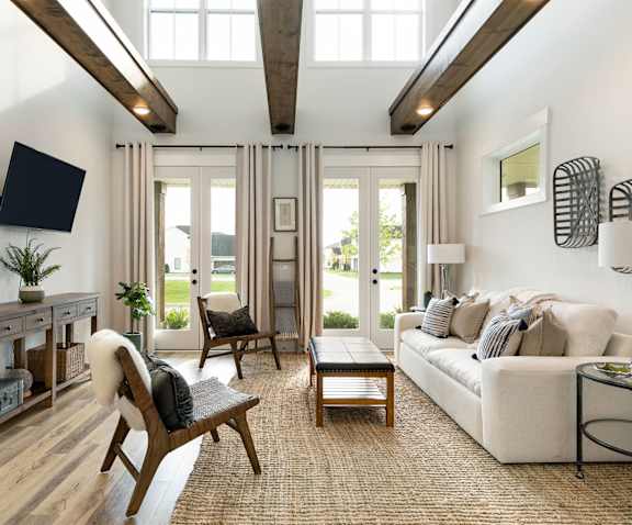 A living room with a white couch and a wooden chair.