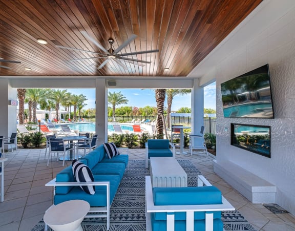 A modern outdoor living space with a wooden ceiling and a television mounted on the wall. at Altis Twin Lakes Apartments, Kissimmee, FL 34744