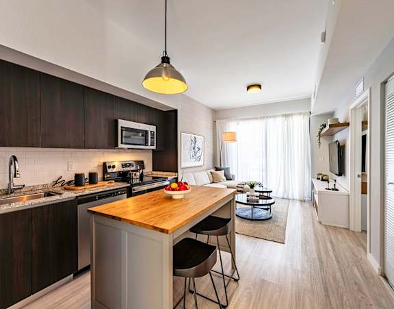 A modern kitchen with dark wood cabinets and a wooden island.