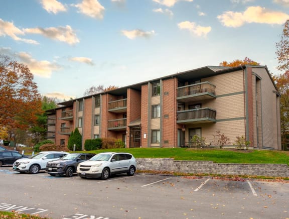 an apartment building with cars parked in a parking lot