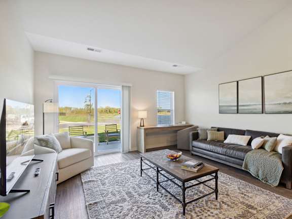 A modern living room with a large window and a view of a tree.