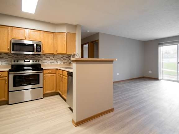 A kitchen with wooden cabinets and a stainless steel oven.