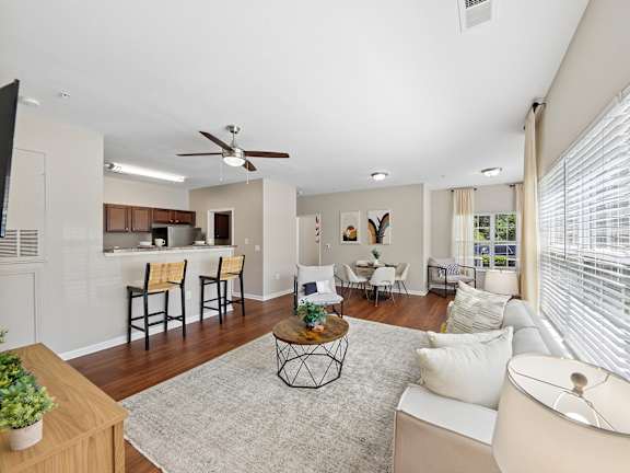A living room with a white couch and a ceiling fan.